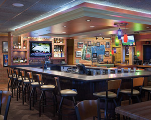 The new Applebee’s prototype design includes a sleeker, slightly larger bar area  with strategically placed TV screens, varied seating styles and a dramatically  lit back bar.