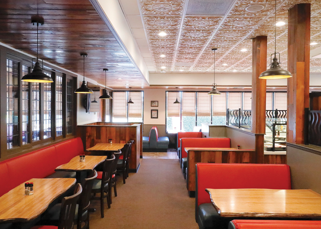 Live edge tabletops and red faux leather were added to the existing furnishings.