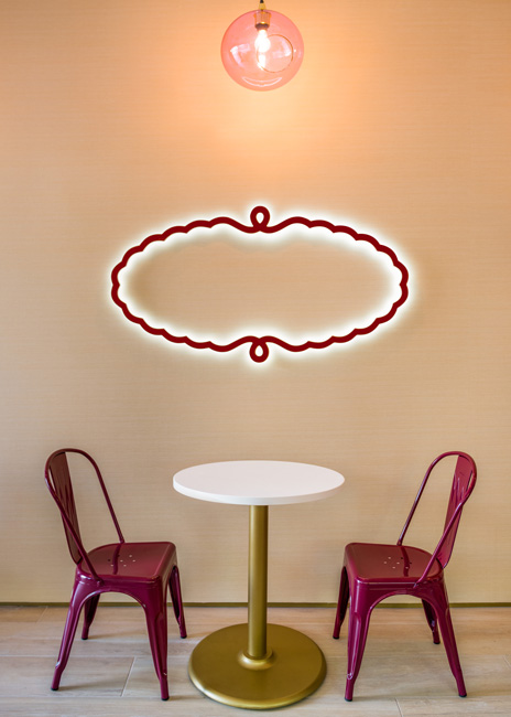 The chain applied its color palette to its chairs and table bases, while the cartouche of the Häagen-Dazs logo serves as a piece of wall decor. 