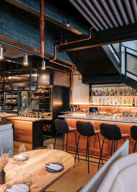 Tucked beneath the staircase, the petite bar is topped in Colorado Yule marble and faced in copper, lending a warm glow to the main-floor dining room. Images courtesy of Fernado Gomes