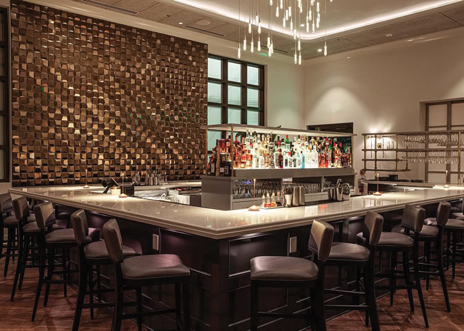 Marbled & Fin's decor includes a modern and dramatic sculptural copper-colored element behind the bar and lush greenery in the dining room. Images courtesy of Andrew Cebulka